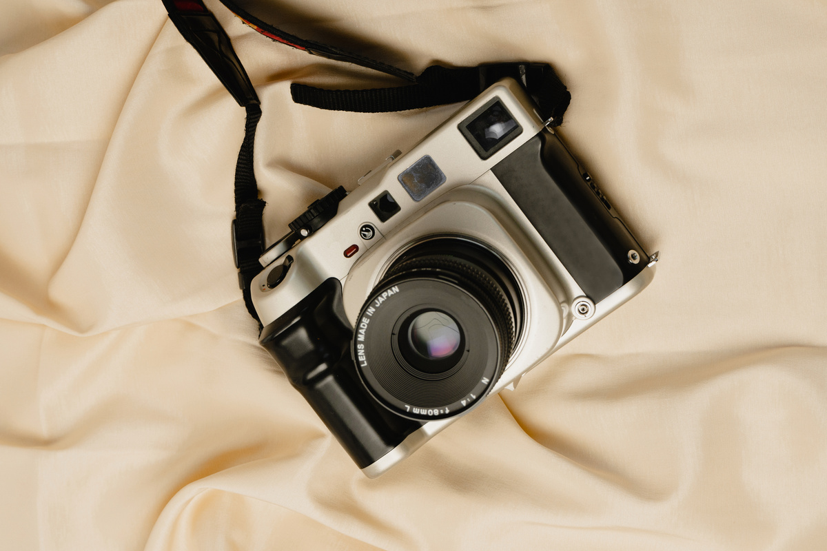 Film Camera on Beige Silk Fabric